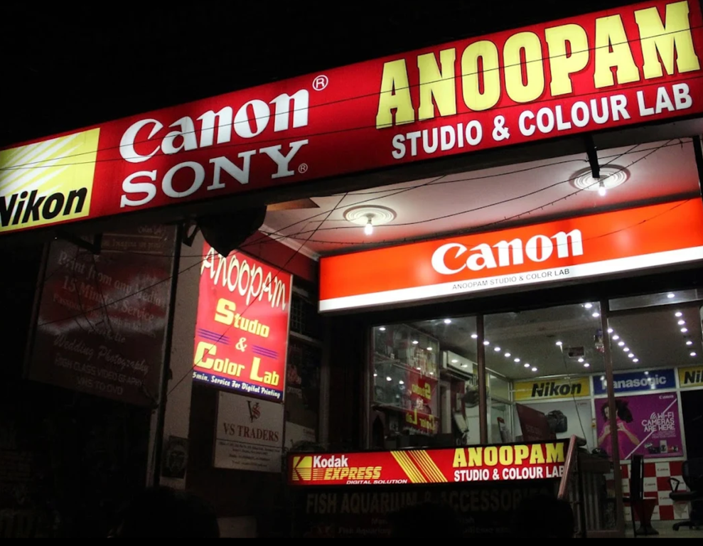 Anoopam Color Lab – Photography & Camera Services. Professional wedding photography, studio shoots and camera accessories including tripods, Nikon, Canon and Sony equipment available. Trusted service with quality work and modern setup. Address: Block C, Sector 7 Dwarka, Phone: 09654036307